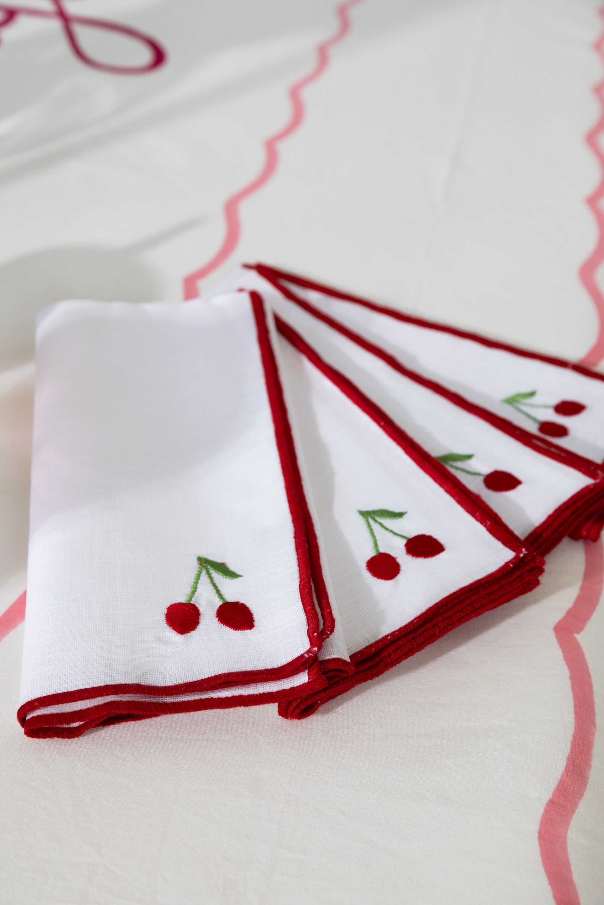 Set of white napkins with red embroidery and cherries on a white background