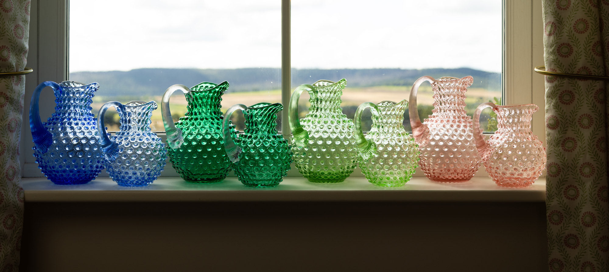 A row of hobnail jugs in two sizes