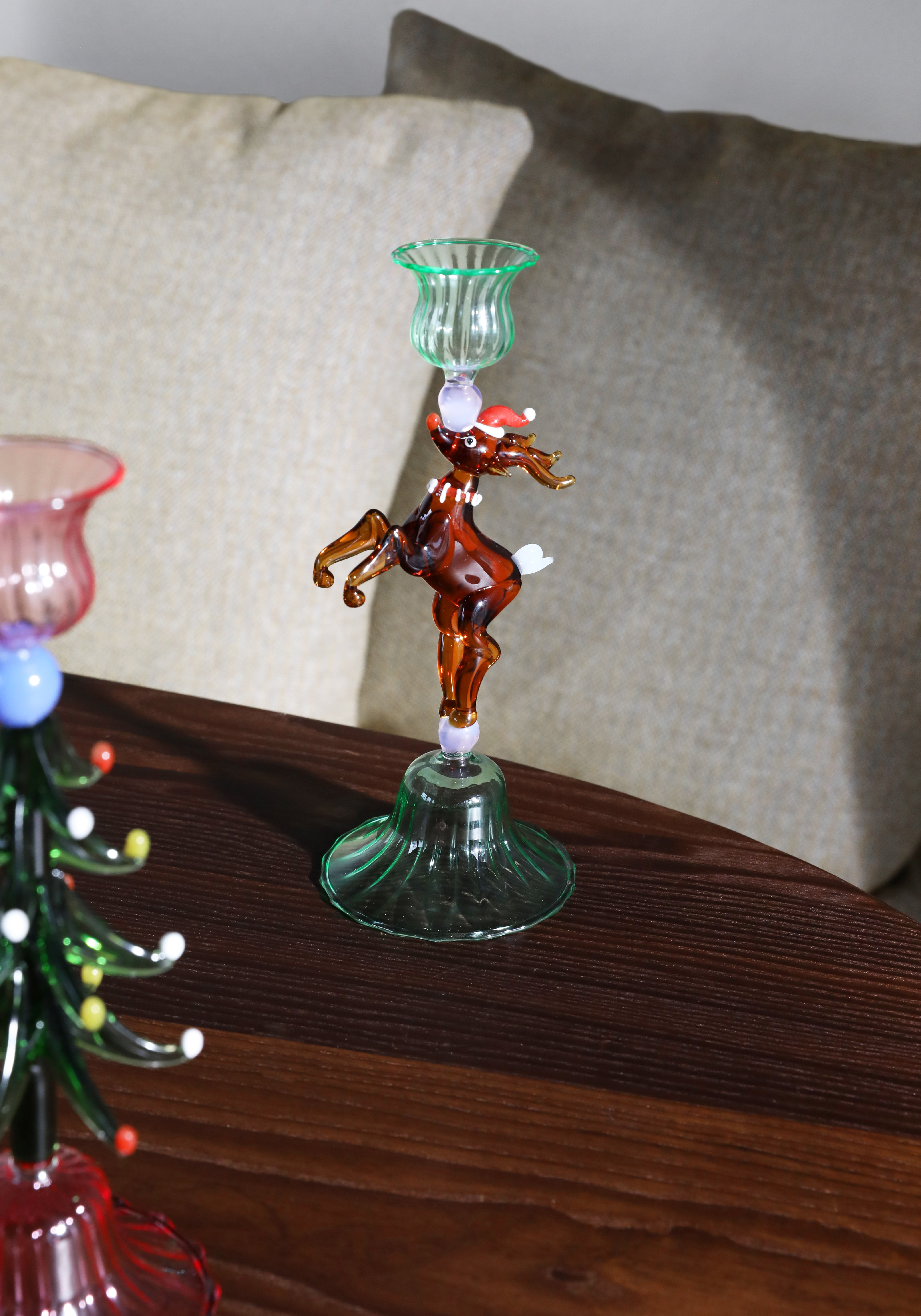 Decorative glass reindeer on a green stand 