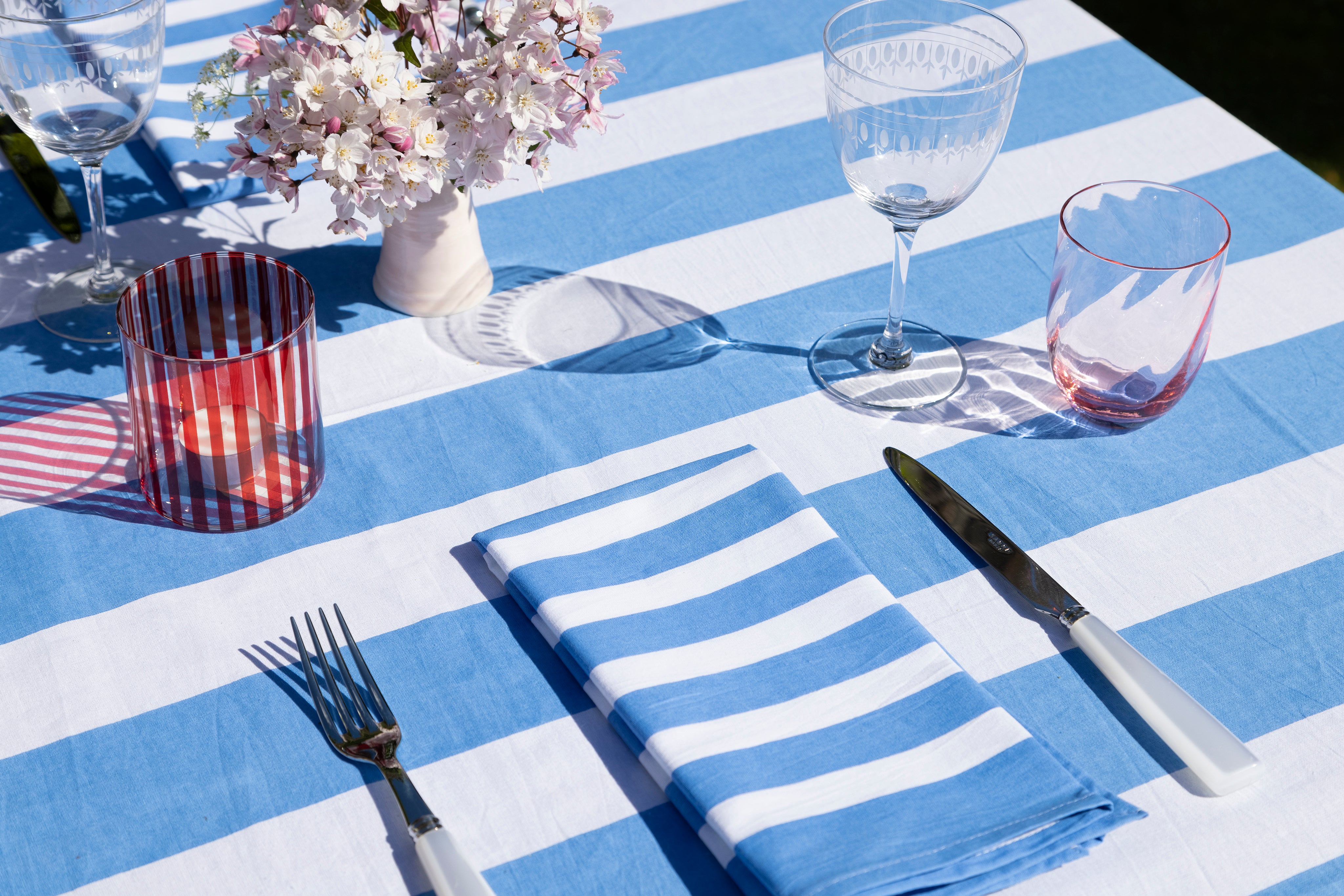 Red striped tea light holder on a blue striped table cloth