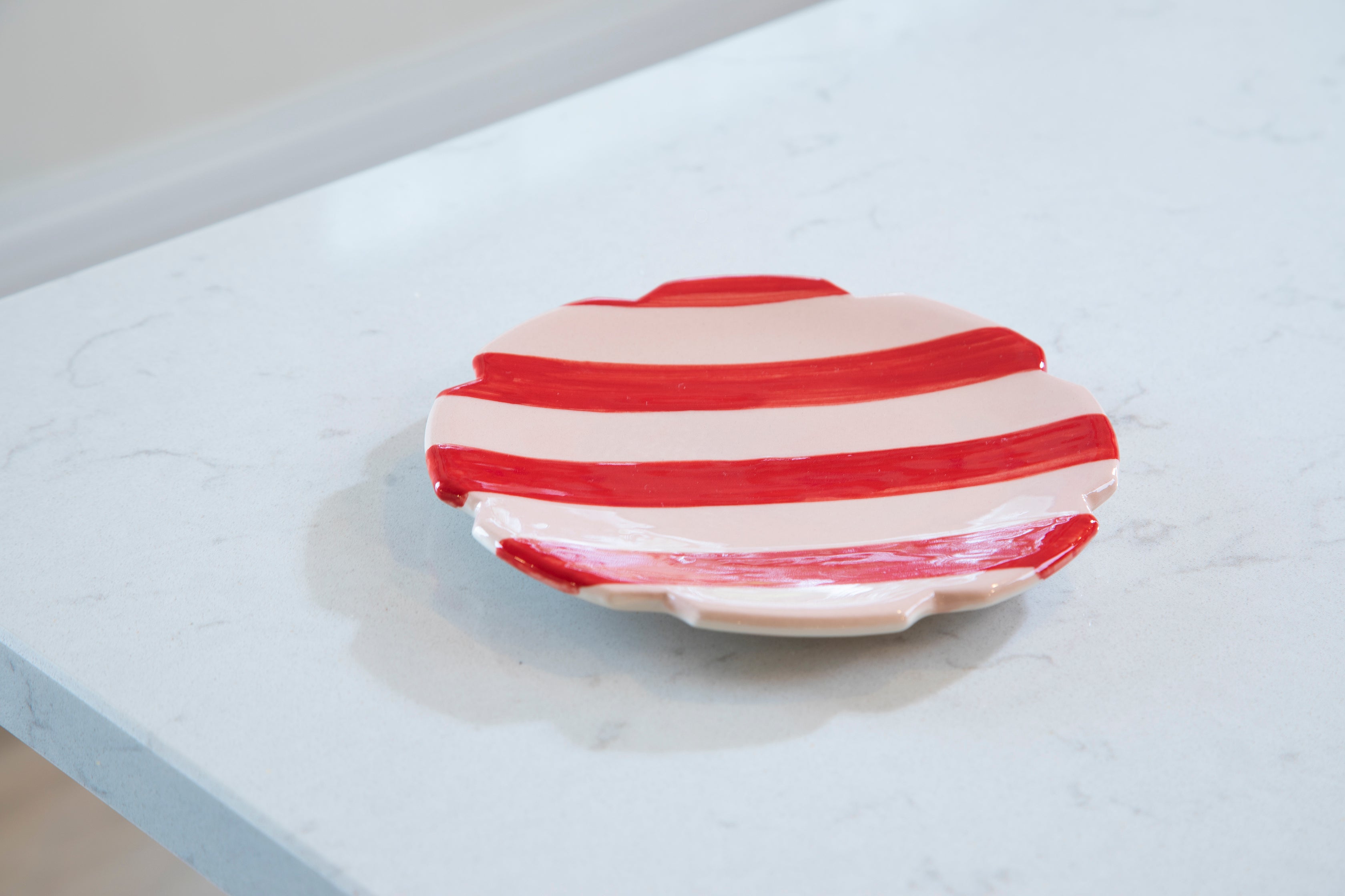 Pink and red Vaisselle striped scalloped side plate